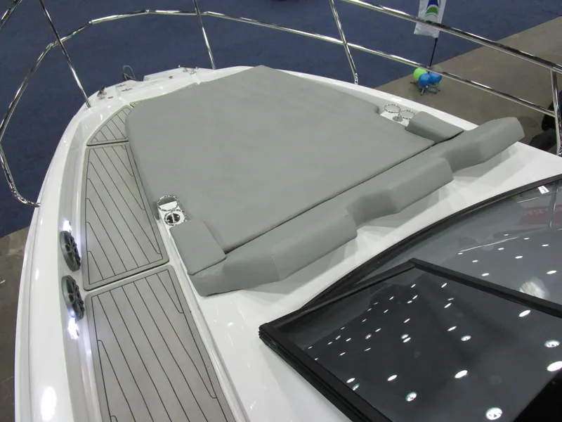 Slide: The Image of 2025 NX Boats 340 Sport Coupe with sleek deck and cushioned sunbed. - 18