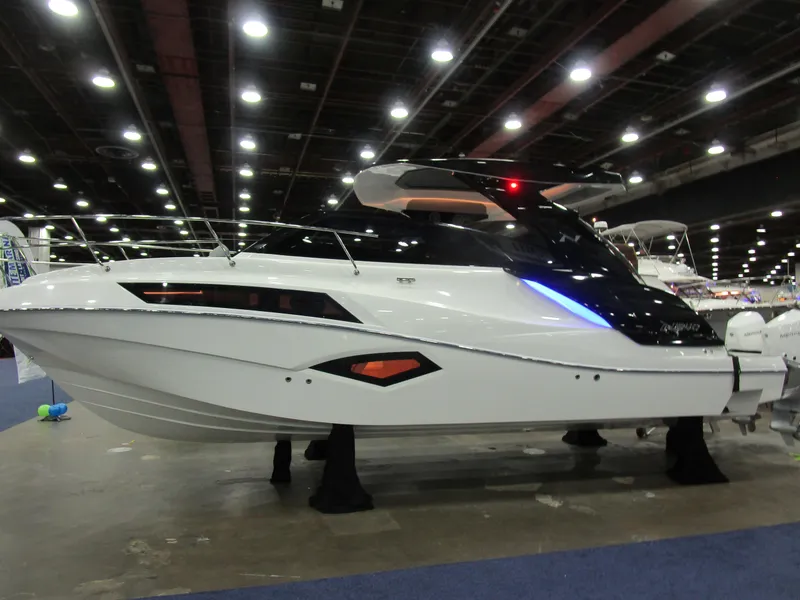 Slide: The Image of 2025 NX Boats 340 Sport Coupe displayed at an indoor boat show. - 2
