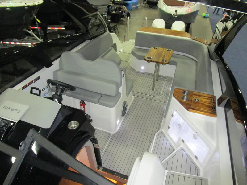 Slide: The Image of 2025 NX Boats 340 Sport Coupe interior with seating and wooden table. - 20