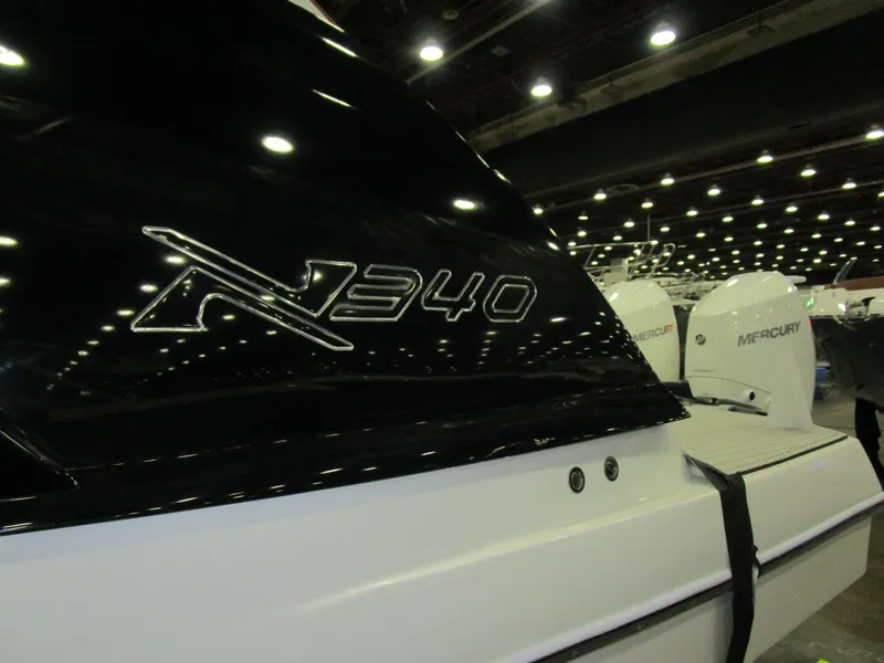 Slide: The Image of 2025 NX Boats 340 Sport Coupe displayed at a boat show with Mercury engines. - 4