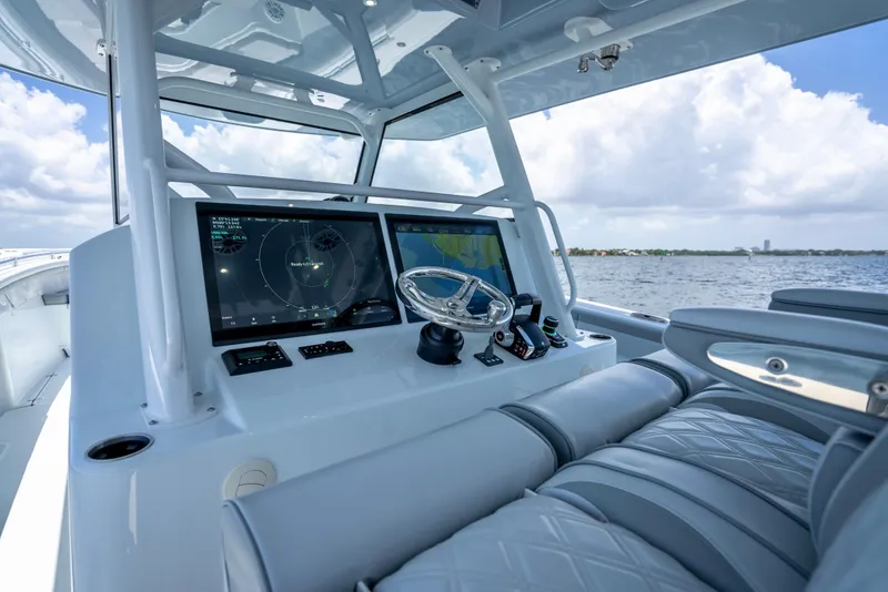 Slide: The Image of 2023 Yellowfin 42 Offshore boat cockpit with advanced navigation screens and luxurious seating. - 14
