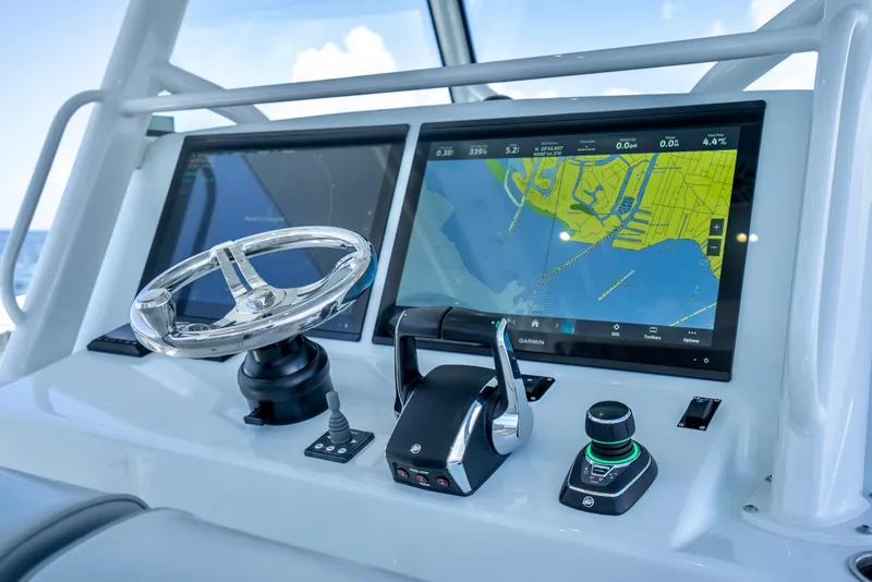 Slide: The Image of Control panel of 2023 Yellowfin 42 Offshore boat with navigation screens and steering wheel. - 25