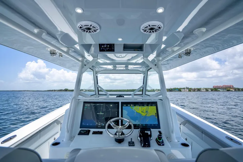 Slide: The Image of 2023 Yellowfin 42 Offshore boat helm with dual navigation screens on open water. - 26