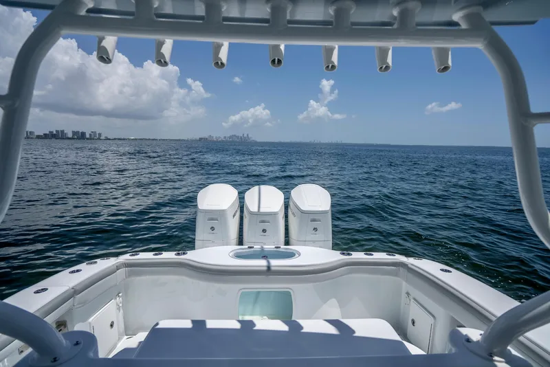 Slide: The Image of 2023 Yellowfin 42 Offshore boat on open sea, clear sky, city skyline in distance. - 36