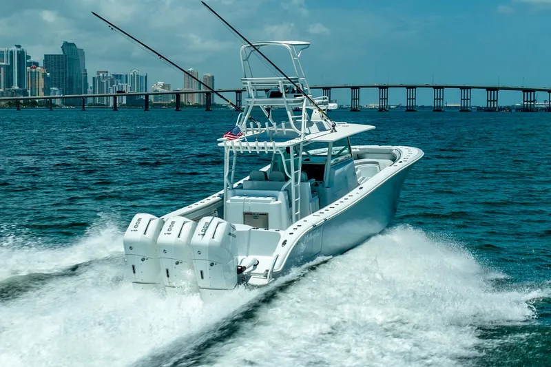 Slide: The Image of 2023 Yellowfin 42 Offshore boat cruising on open water near a city skyline. - 4