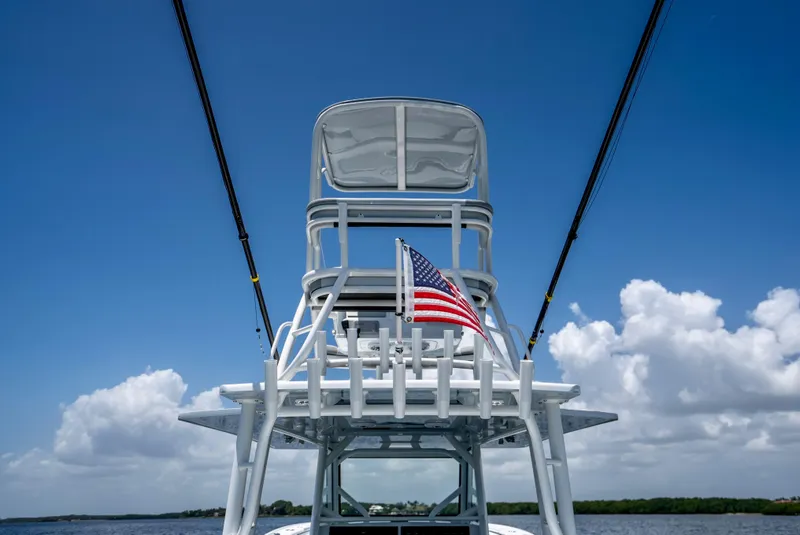 Slide: The Image of 2023 Yellowfin 42 Offshore boat with American flag, clear sky, and ocean backdrop. - 41