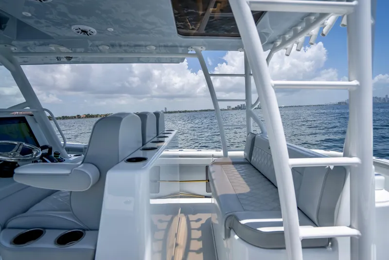 Slide: The Image of 2023 Yellowfin 42 Offshore boat interior with seating, ocean view, and clear sky. - 43
