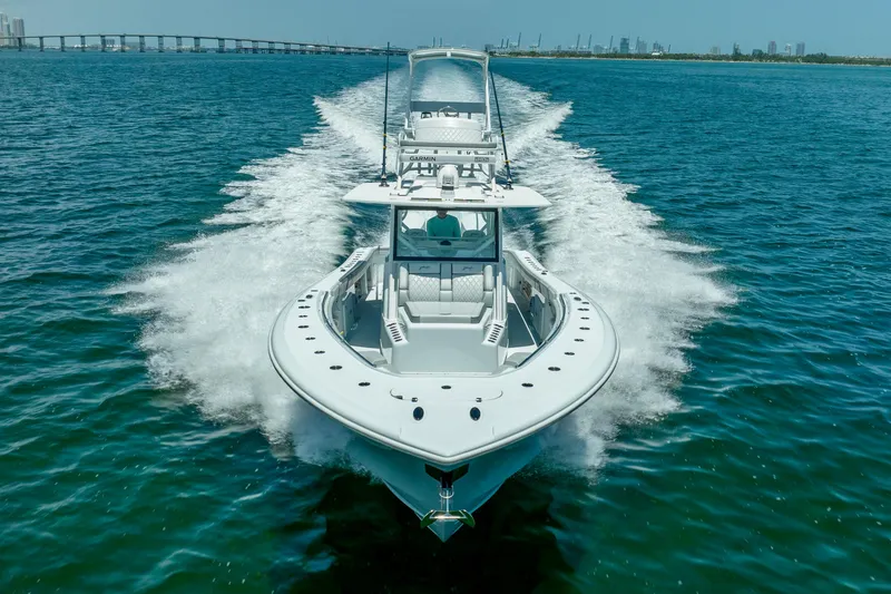 Slide: The Image of 2023 Yellowfin 42 Offshore boat cruising on open water, bridge in background. - 6