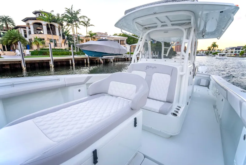 Slide: The Image of 2016 Yellowfin 39 Offshore boat with luxurious seating, docked near waterfront homes. - 25