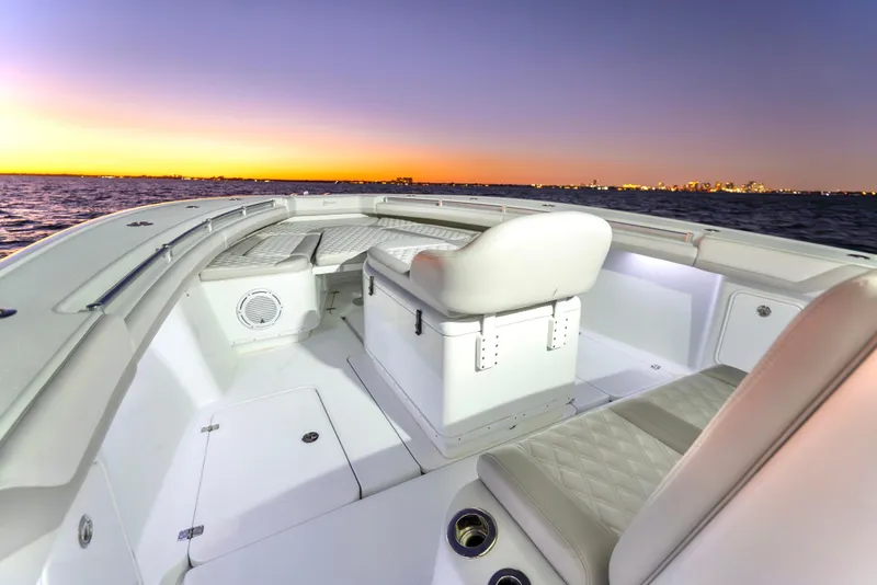 Slide: The Image of 2016 Yellowfin 39 Offshore boat interior at sunset, showcasing seating and ocean view. - 26