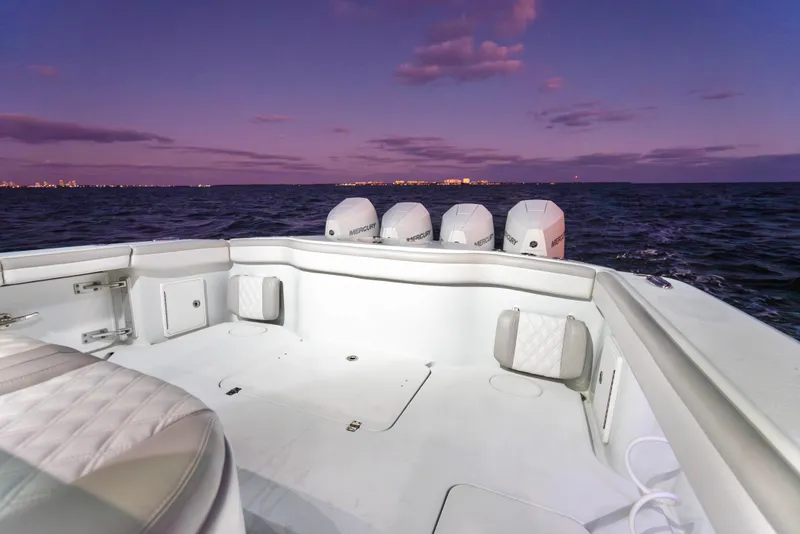 Slide: The Image of 2016 Yellowfin 39 Offshore boat at sunset, featuring spacious deck and multiple engines. - 31