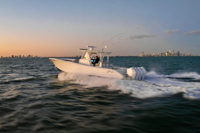 Slide: The Image of 2016 Yellowfin 39 Offshore boat cruising at sunset near city skyline. - 9