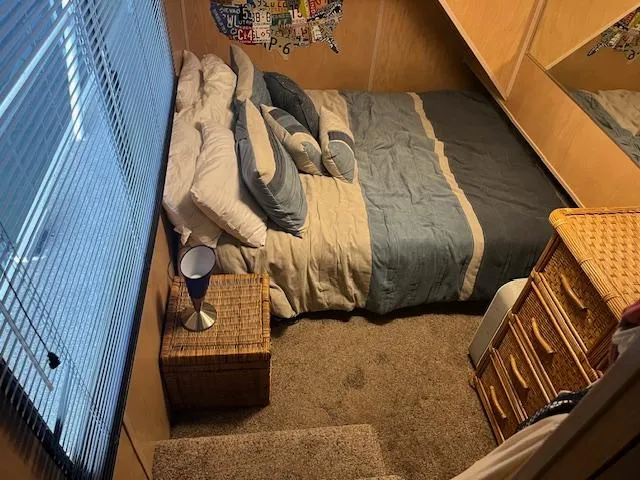 Slide: The Image of Cozy bedroom in 1988 Stardust Cruisers houseboat with blue bedding and wicker furniture. - 10