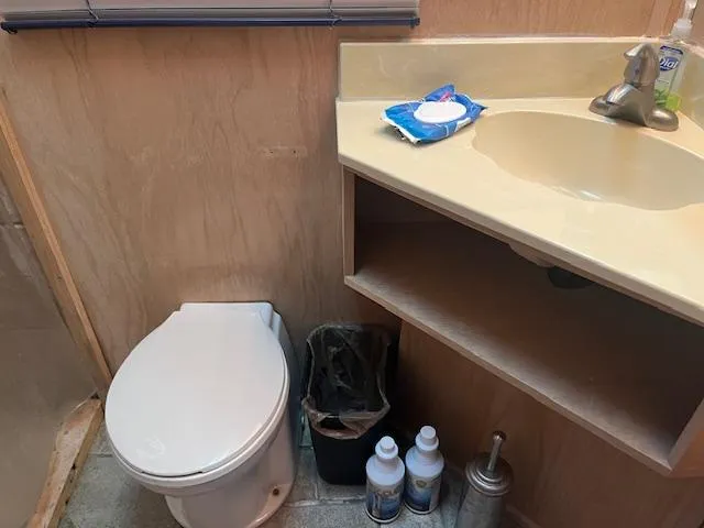 Slide: The Image of Bathroom interior of 1988 Stardust Cruisers houseboat with sink, toilet, and cleaning supplies. - 12