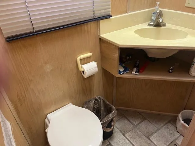 Slide: The Image of 1988 Stardust Cruisers houseboat bathroom with sink, toilet, and storage shelves. - 13