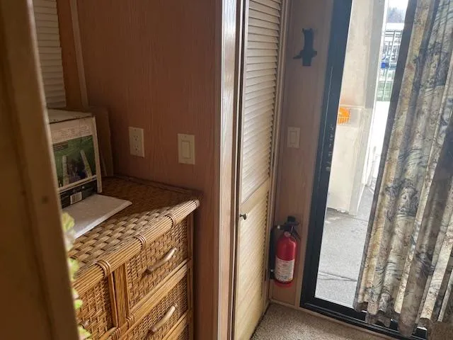 Slide: The Image of 1988 Stardust Cruisers houseboat interior with wicker furniture, fire extinguisher, and sliding door. - 14