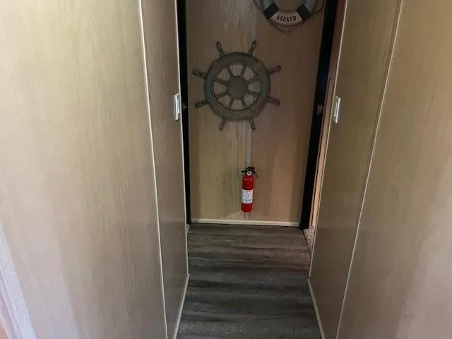 Slide: The Image of Narrow hallway in 1988 Stardust Cruisers houseboat with nautical decor and fire extinguisher. - 16