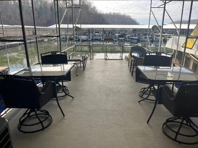 Slide: The Image of 1988 Stardust Cruisers houseboat deck with tables and chairs overlooking marina. - 18
