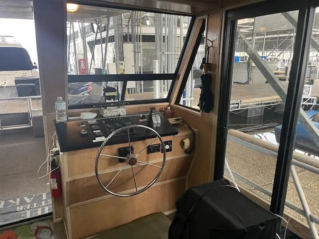 Slide: The Image of 1988 Stardust Cruisers 15 x 65 houseboat helm with steering wheel and control panel. - 2