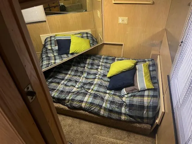 Slide: The Image of Cozy bedroom in 1988 Stardust Cruisers houseboat with plaid bedding and colorful pillows. - 9