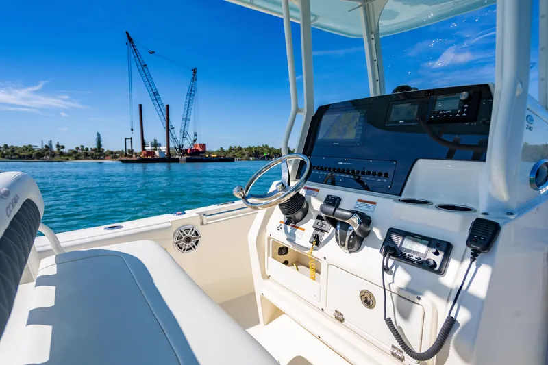Slide: The Image of 2022 Cobia 240 CC boat dashboard with ocean view and construction cranes in background. - 10