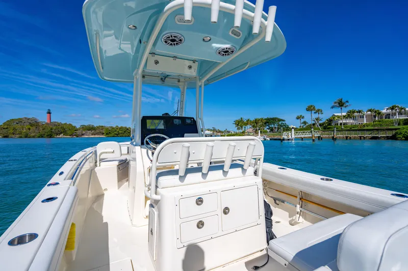 Slide: The Image of 2022 Cobia 240 CC boat on clear blue water with scenic shoreline. - 17