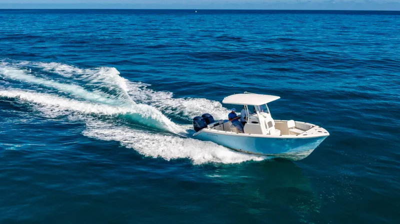 Slide: The Image of 2022 Cobia 240 CC boat cruising on open blue ocean waters. - 2