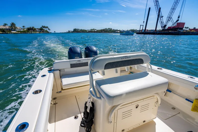 Slide: The Image of 2022 Cobia 240 CC boat cruising on sunny waters with dual engines. - 21