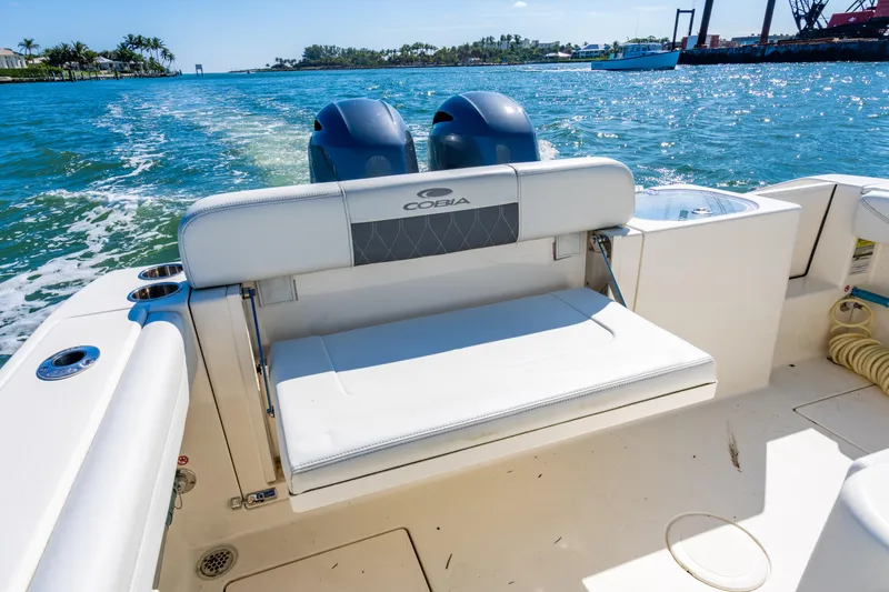 Slide: The Image of 2022 Cobia 240 CC boat with dual engines cruising on a sunny day. - 22