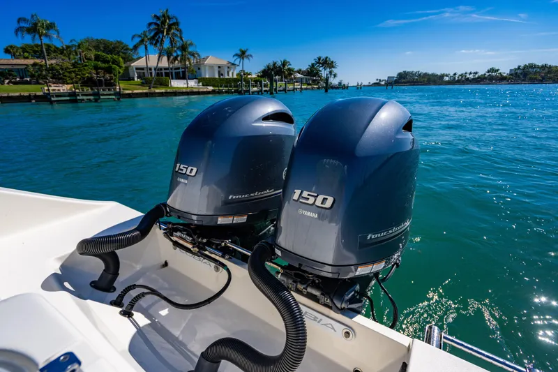 Slide: The Image of Twin Yamaha 150 engines on a 2022 Cobia 240 CC boat, cruising in sunny waters. - 24