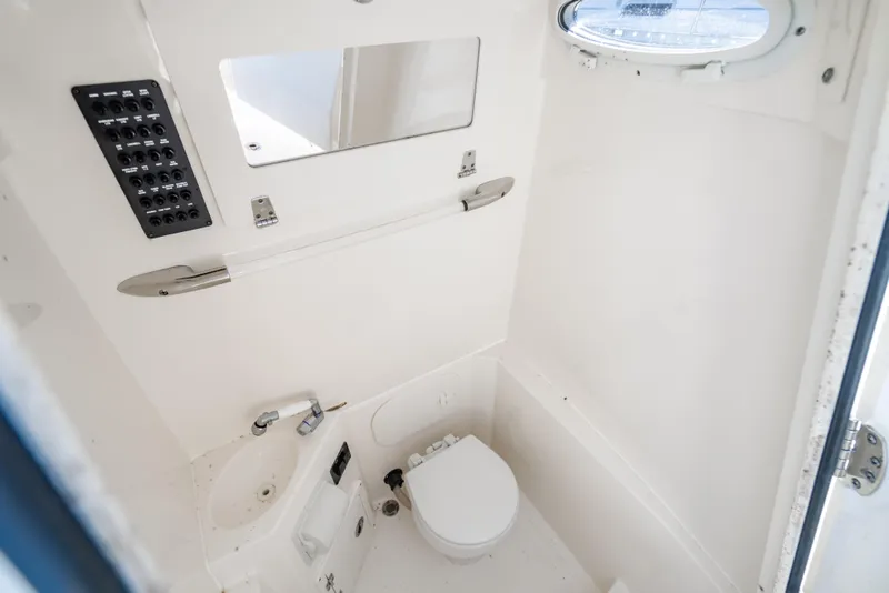 Slide: The Image of Interior of 2022 Cobia 240 CC boat bathroom with toilet and sink. - 26