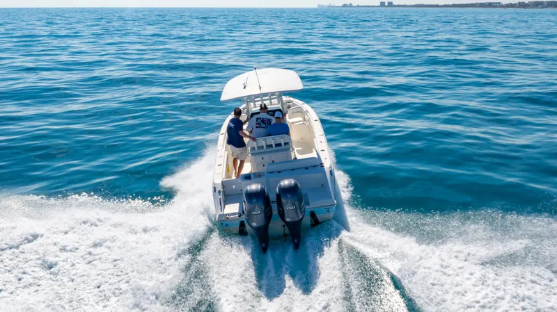 Slide: The Image of 2022 Cobia 240 CC boat cruising on open blue water. - 29
