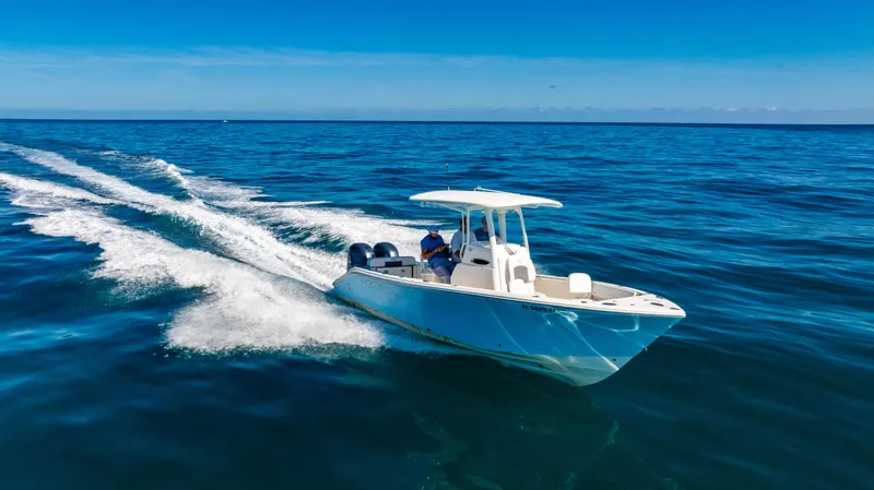 Slide: The Image of 2022 Cobia 240 CC boat cruising on open ocean under clear blue sky. - 3