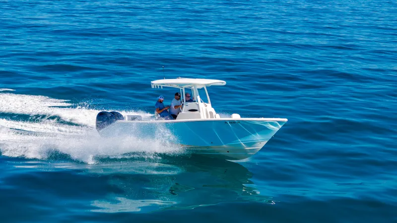 Slide: The Image of 2022 Cobia 240 CC boat cruising on open blue water. - 35