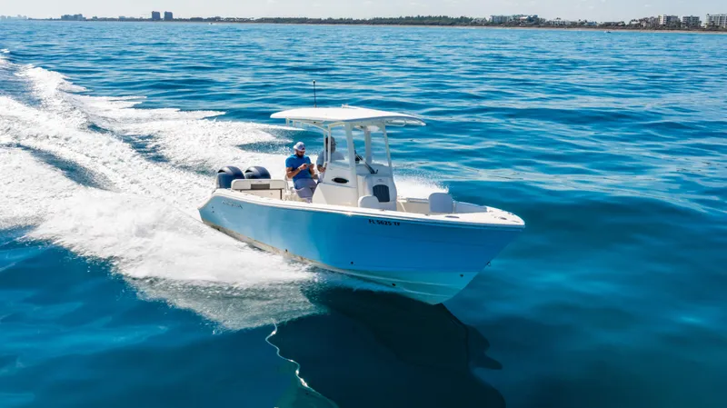 Slide: The Image of 2022 Cobia 240 CC boat cruising on open blue water, clear sky in background. - 37