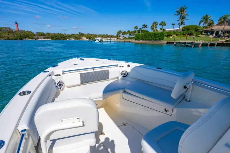 Slide: The Image of 2022 Cobia 240 CC boat interior with seating, on a sunny day by the water. - 4