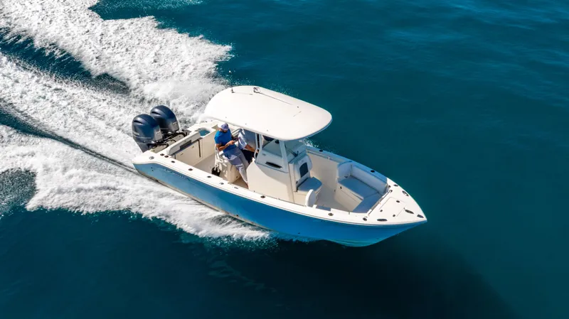 Slide: The Image of 2022 Cobia 240 CC boat cruising on open water, featuring twin engines. - 41