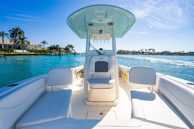 Slide: The Image of 2022 Cobia 240 CC boat on clear blue water, sunny day, palm trees in background. - 6