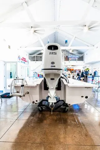Slide: The Image of 2025 Majek 18 M2 boat with 115 HP engine displayed indoors. - 3