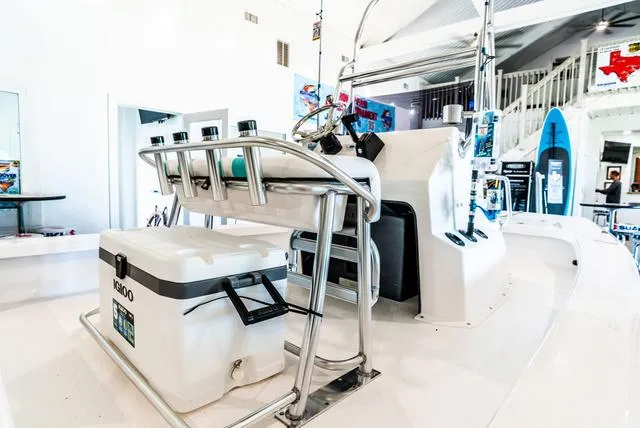 Slide: The Image of 2025 Majek 18 M2 boat interior with console and cooler in showroom. - 4