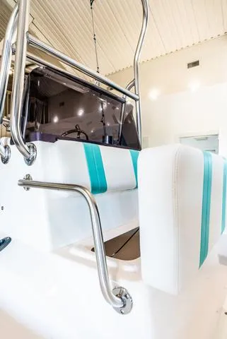 Slide: The Image of 2025 Majek 18 M2 boat interior with white and teal seating, stainless steel railings. - 7