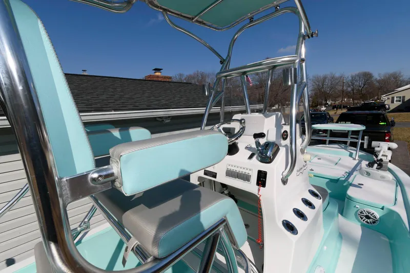 Slide: The Image of 2020 Shallow Sport 24 Modified V boat interior with teal seating and control panel. - 11