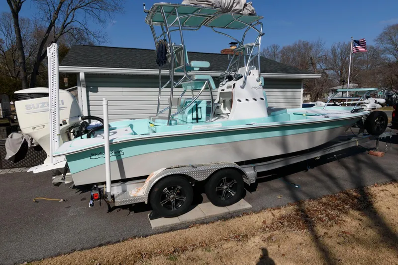Slide: The Image of 2020 Shallow Sport 24 Modified V boat on trailer, parked outdoors. - 2