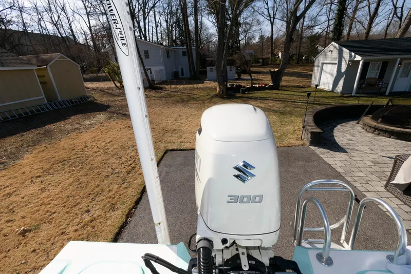 Slide: The Image of 2020 Shallow Sport 24 Modified V boat with Suzuki 300 outboard motor in a backyard setting. - 20