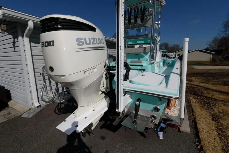 Slide: The Image of 2020 Shallow Sport 24 Modified V boat with Suzuki 300 outboard motor, parked outdoors. - 21
