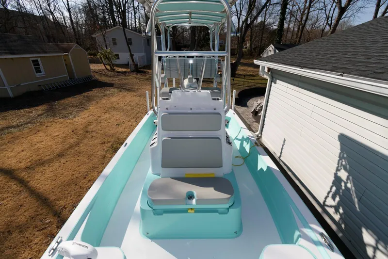 Slide: The Image of 2020 Shallow Sport 24 Modified V boat, light blue interior, parked outdoors near a house. - 5