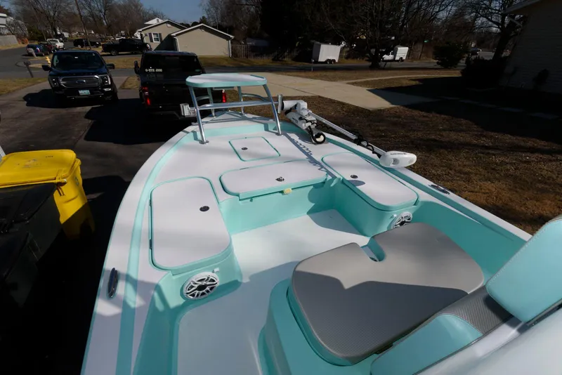Slide: The Image of 2020 Shallow Sport 24 Modified V boat with teal interior, parked on a driveway. - 6
