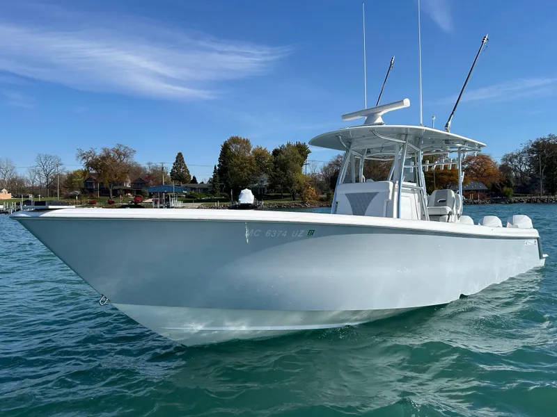 Slide: The Image of 2022 Contender 35 ST boat on clear water, sunny day, trees in background. - 1