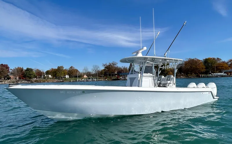 Slide: The Image of 2022 Contender 35 ST boat on water, clear sky, trees in background. - 2
