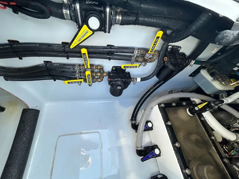 Slide: The Image of Engine compartment of a 2022 Contender 35 ST boat, showcasing hoses and valves. - 21